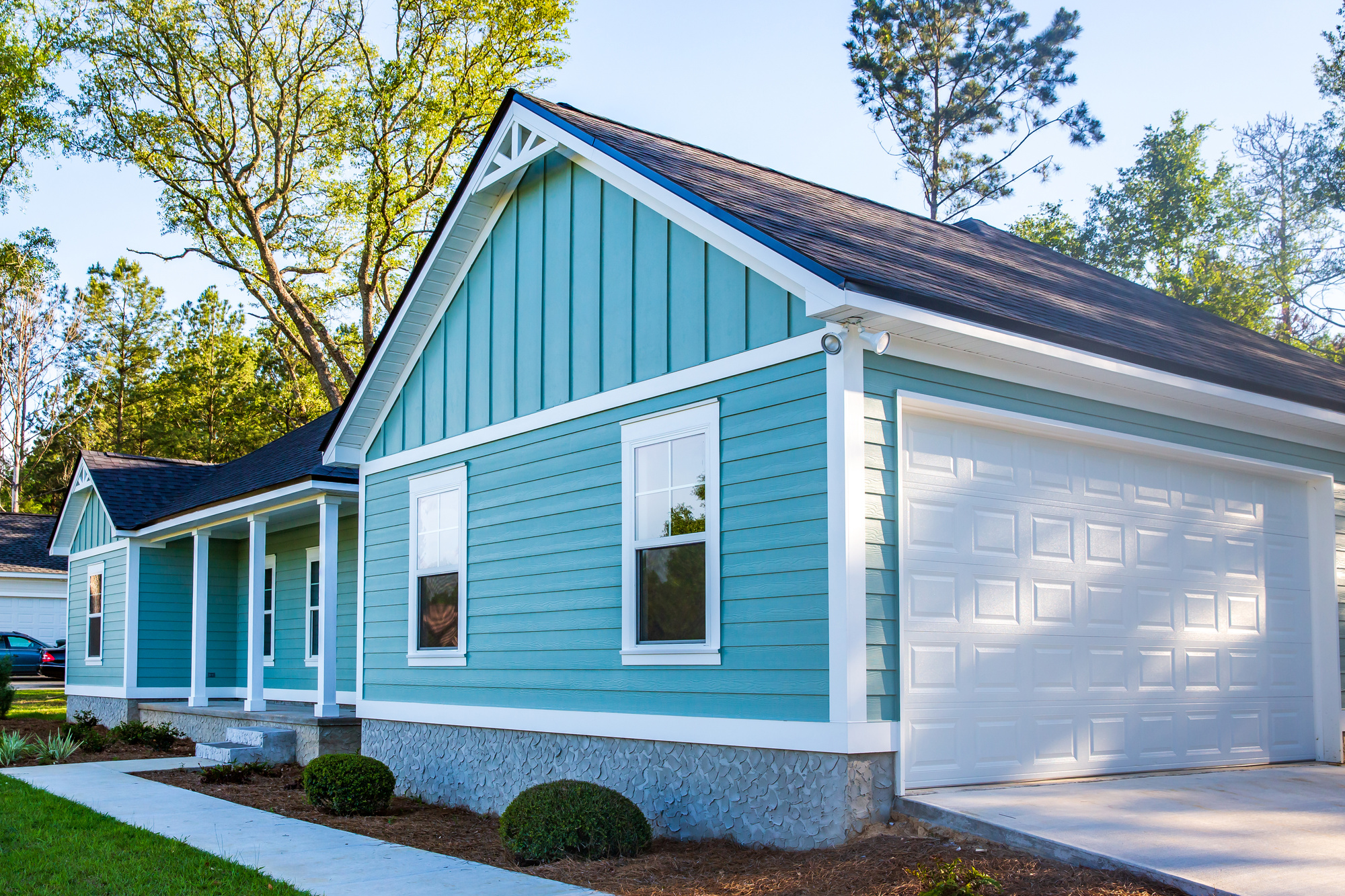 Blue vinyl siding on a house with a white garage door