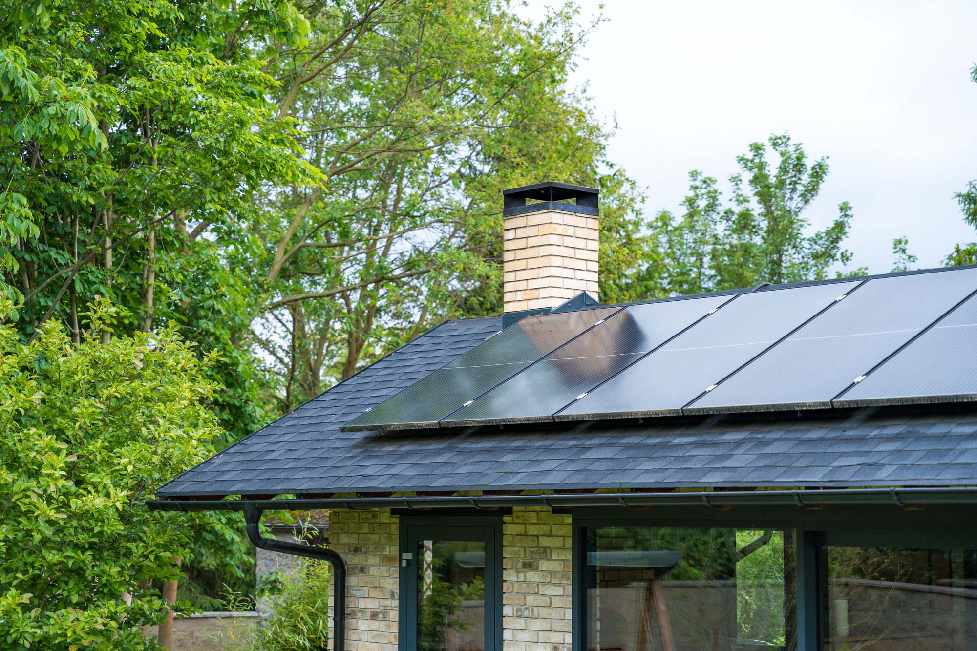 Solar panels on the asphalt shingle roof of a brick house