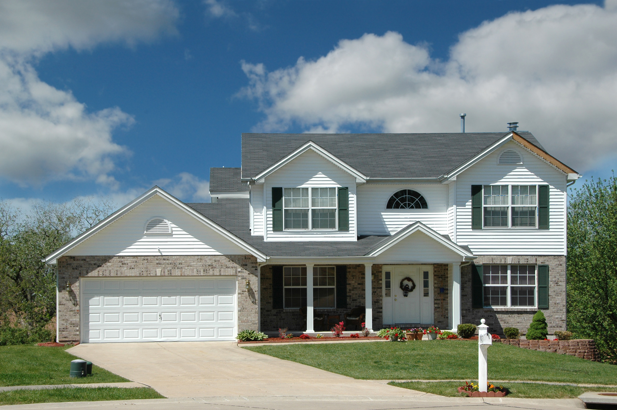 Two-story white and brick house with an asphalt shingle roof