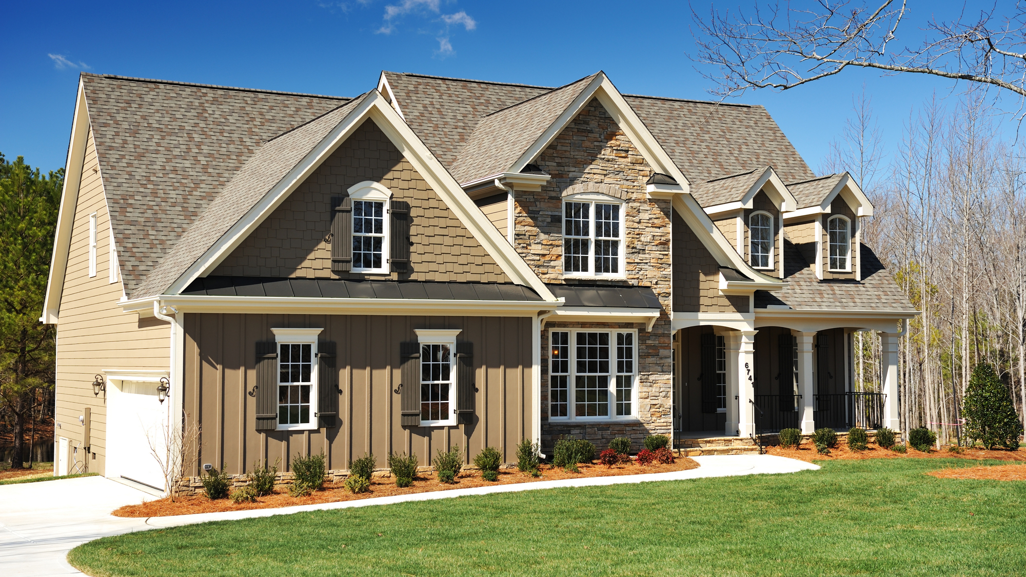 Suburban house with mixed siding and an asphalt shingle roof.