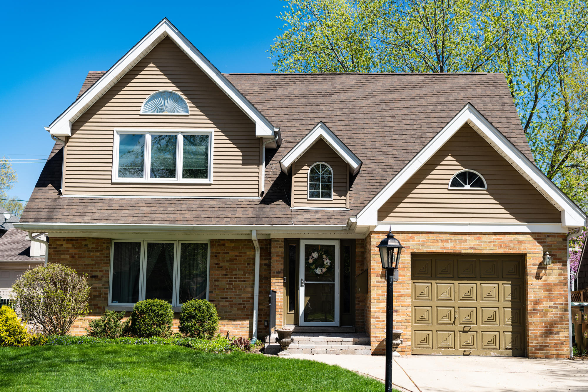 Springfield, OH house with an asphalt shingle roof and green lawn.