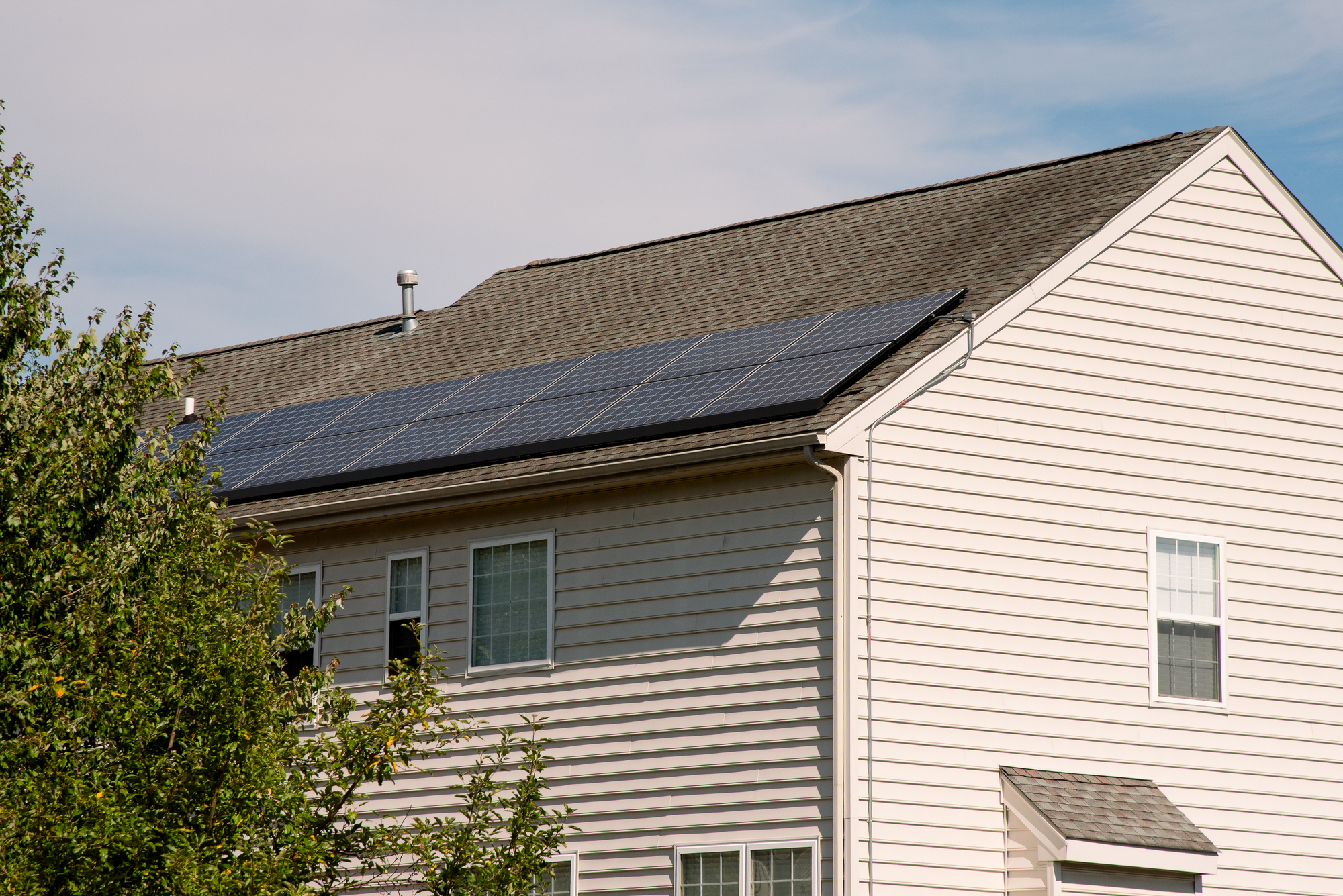 Large house with solar panels on an asphalt shingle roof