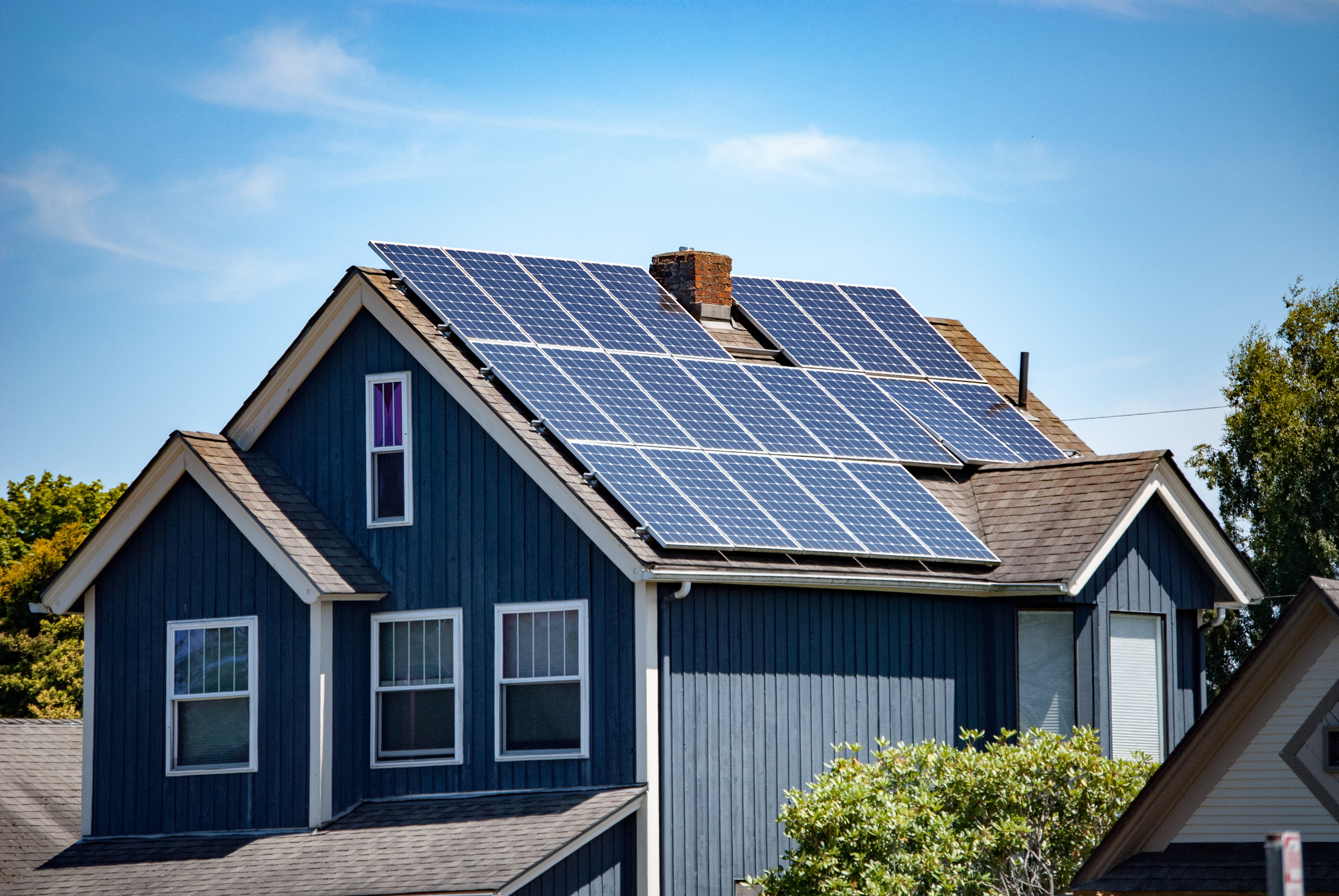 Solar panels on a blue two-story house
