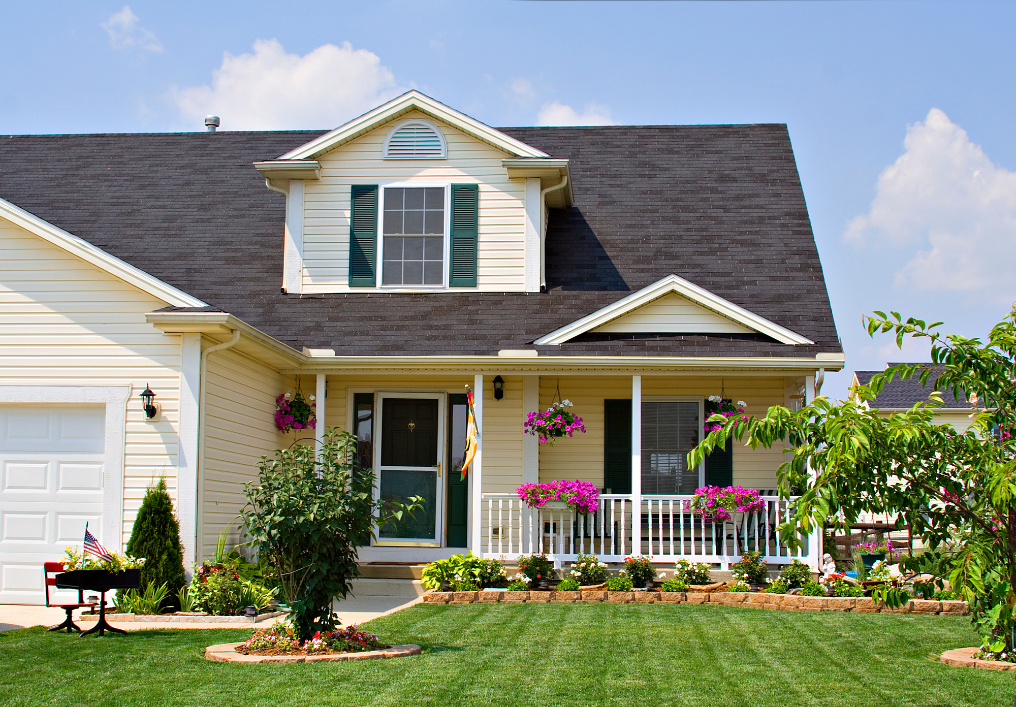 Yellow two-story house with a porch and shingle roof