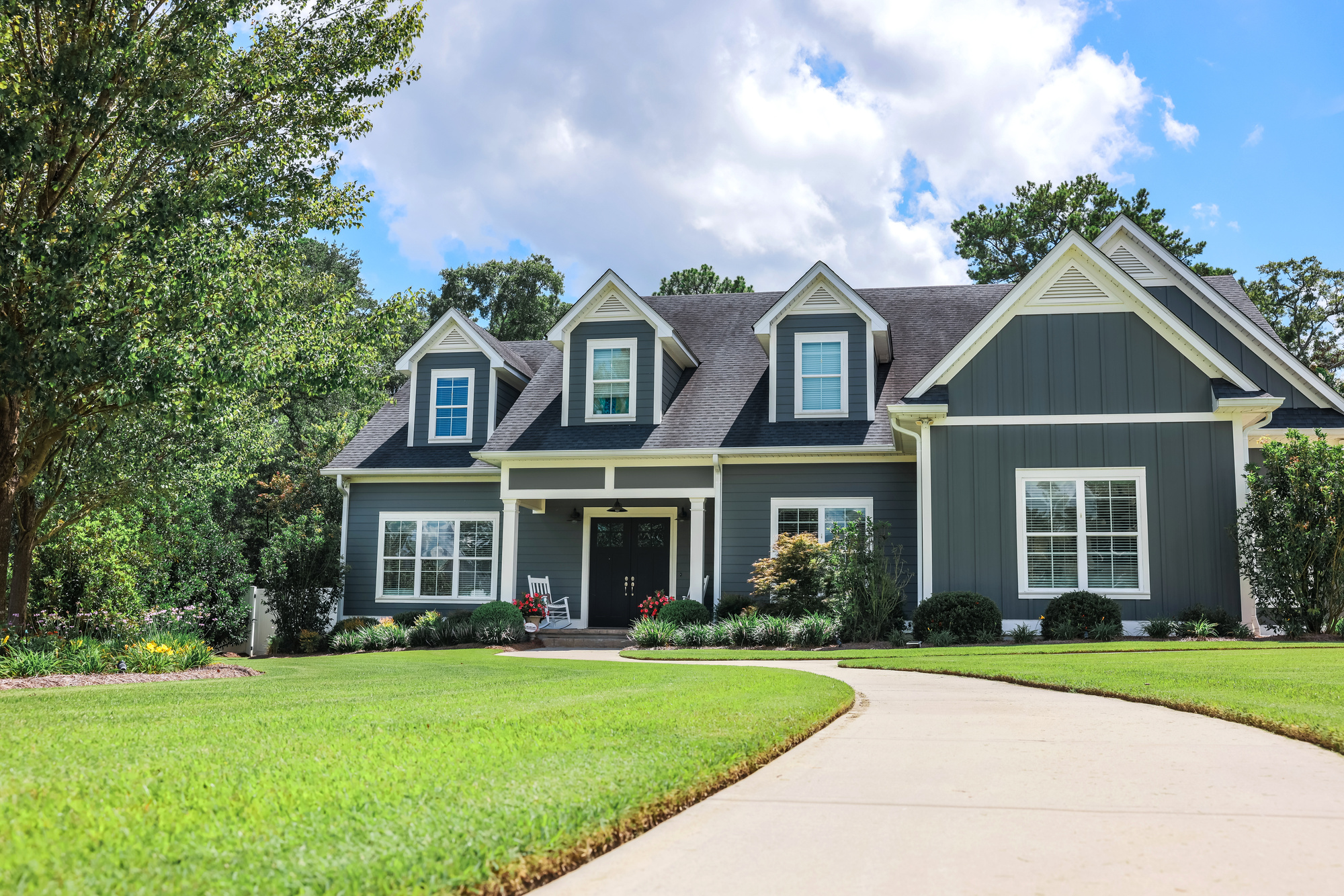 Two-story blue house with large windows