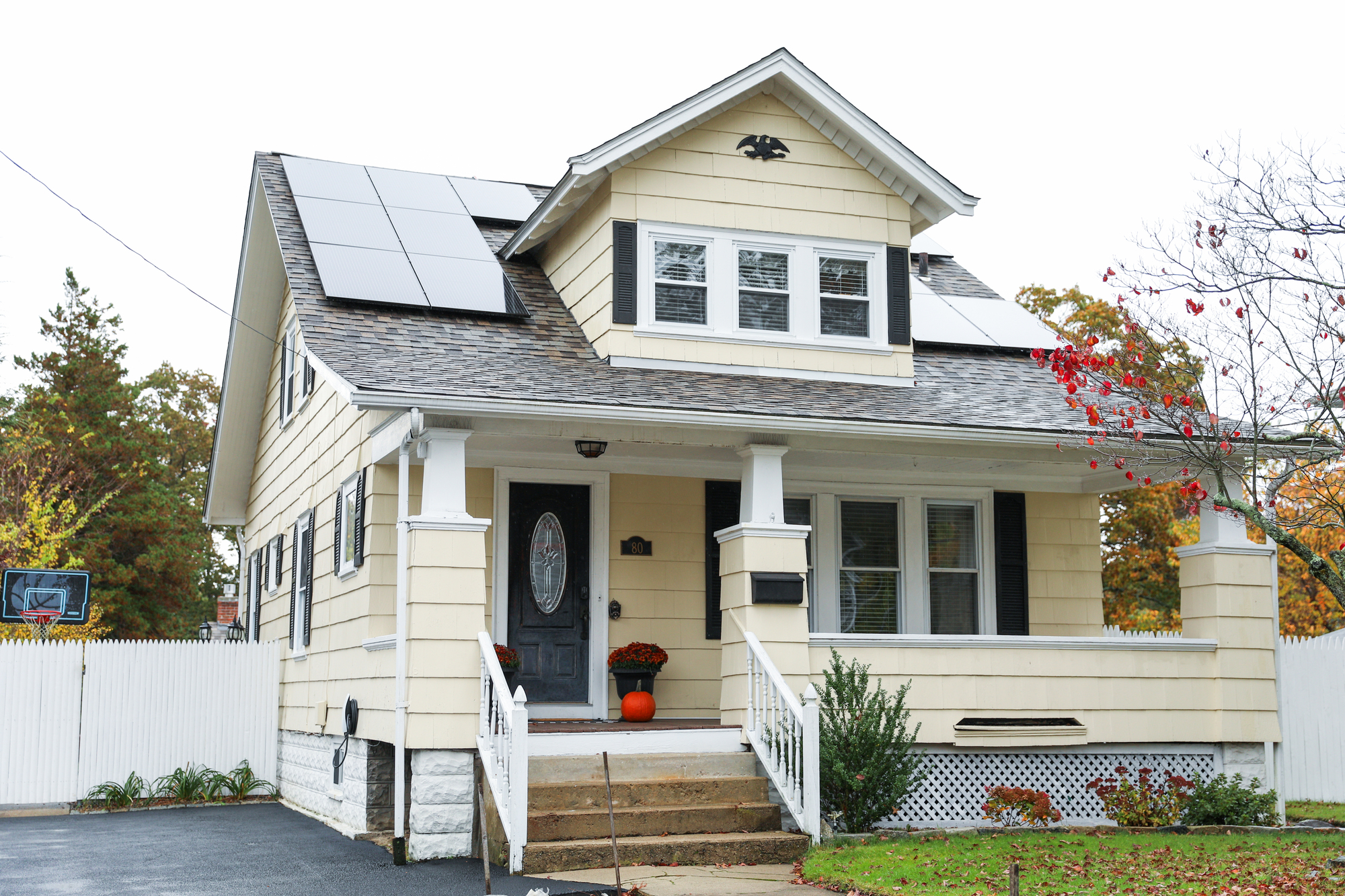 Solar panels on a yellow house and a shingle roof